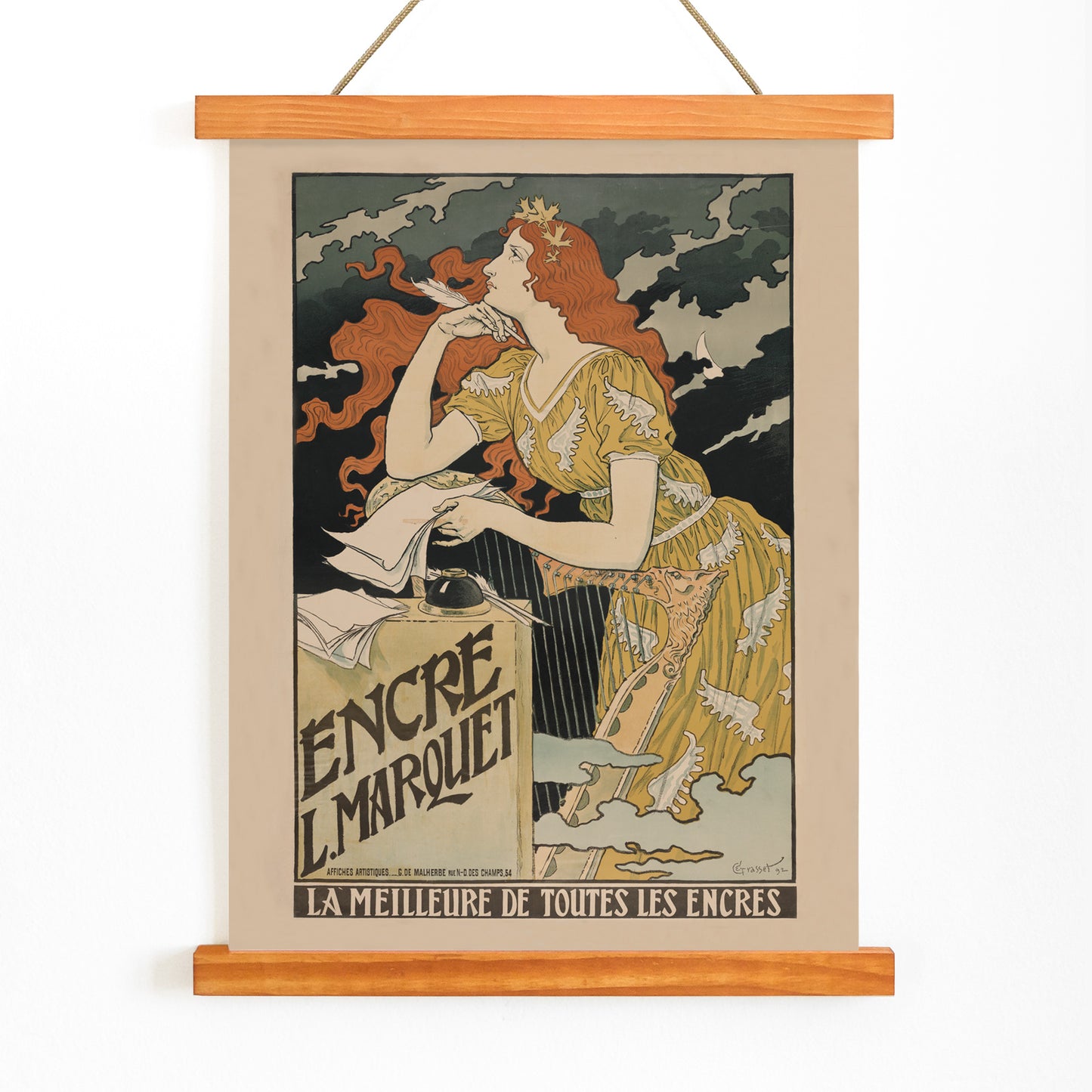 Art Nouveau poster of a woman in a yellow dress with flowing red hair writing at a desk for Encre Marquet by Eugene Grasset, with wooden magnetic frame on white background