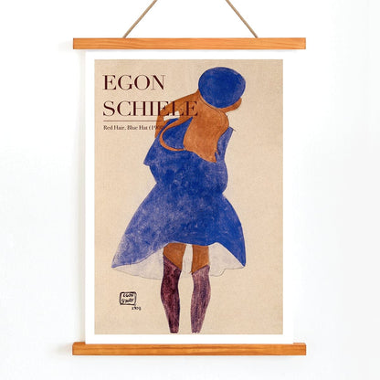 Egon Schiele exhibition poster featuring Red Hair Blue Hat artwork showing a woman with red hair in a blue dress and hat, with wooden magnetic frame on white background