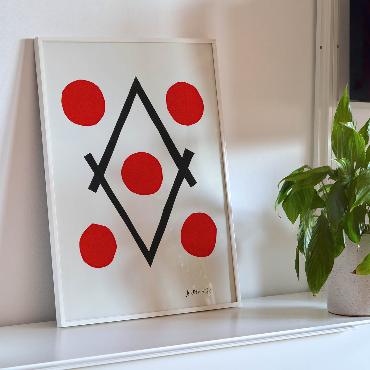 Henri Matisse Losange poster with five red circles around intersecting black lines forming a diamond on white ground, framed and displayed in modern living room decor