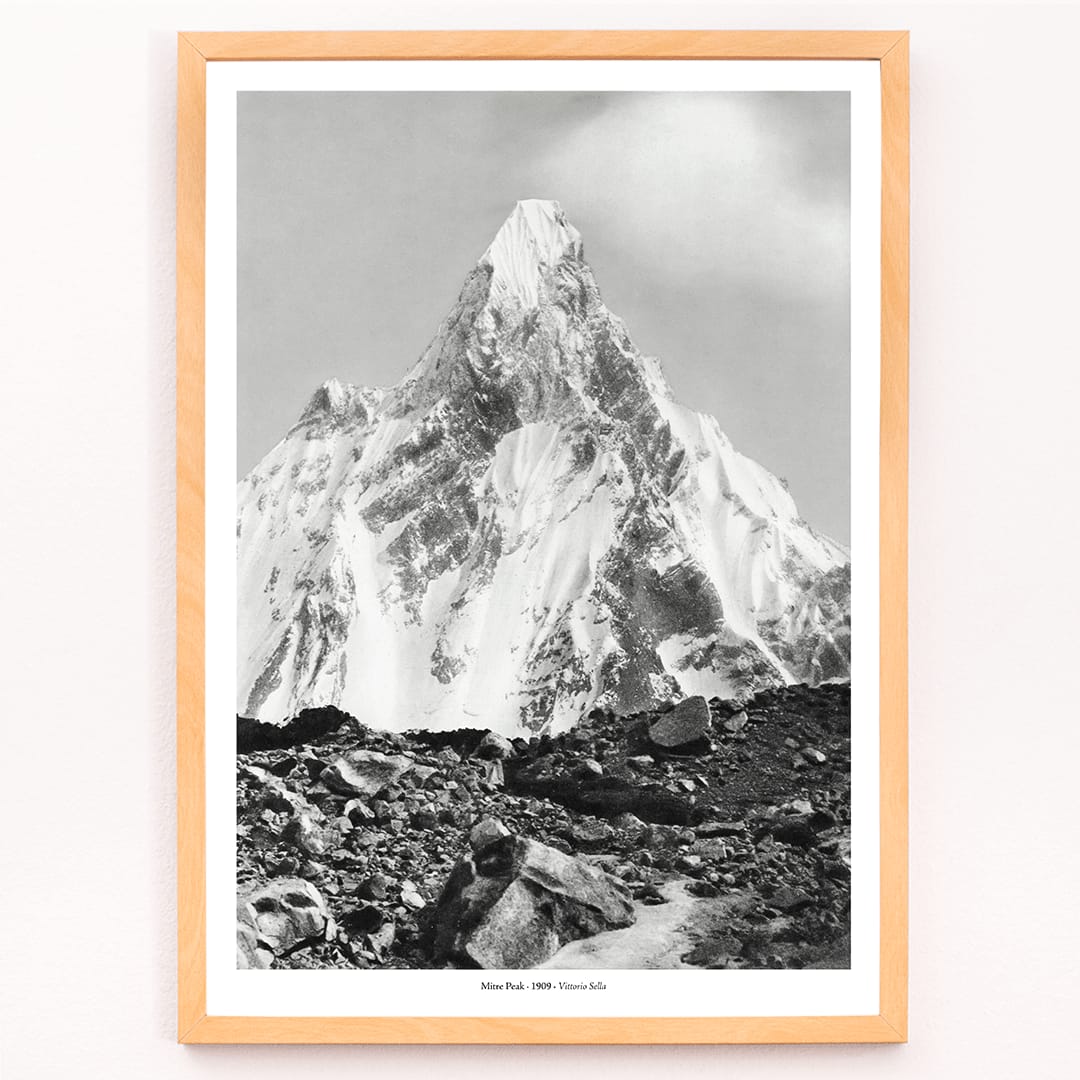 Mitre Peak surrounded by rocky terrain and snowy peak seen from Baltoro Glacier by Vittorio Sella, framed and displayed in modern living room decor