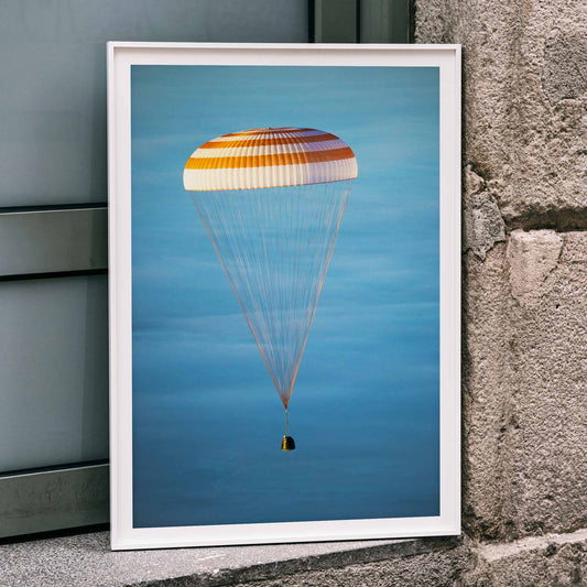 Soyuz TMA-14M spacecraft descending with parachute against blue sky NASA Expedition 42 landing poster artwork, framed and displayed in home decor