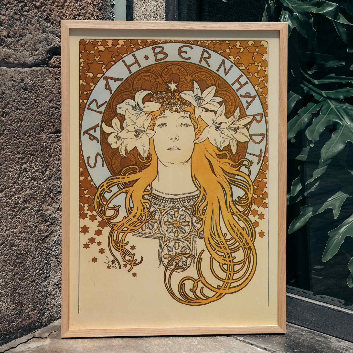 Art Nouveau poster of Sarah Bernhardt with flowing hair floral crown and lilies by Alphonse Mucha from La Plume, framed and displayed in home decor