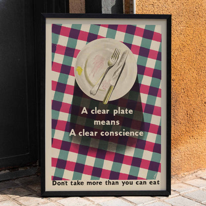 Poster by James Fitton promoting mindful eating habits showing an empty plate with cutlery on a checkered tablecloth featuring the text A Clear Plate Means a Clear Conscience, framed and displayed in home decor