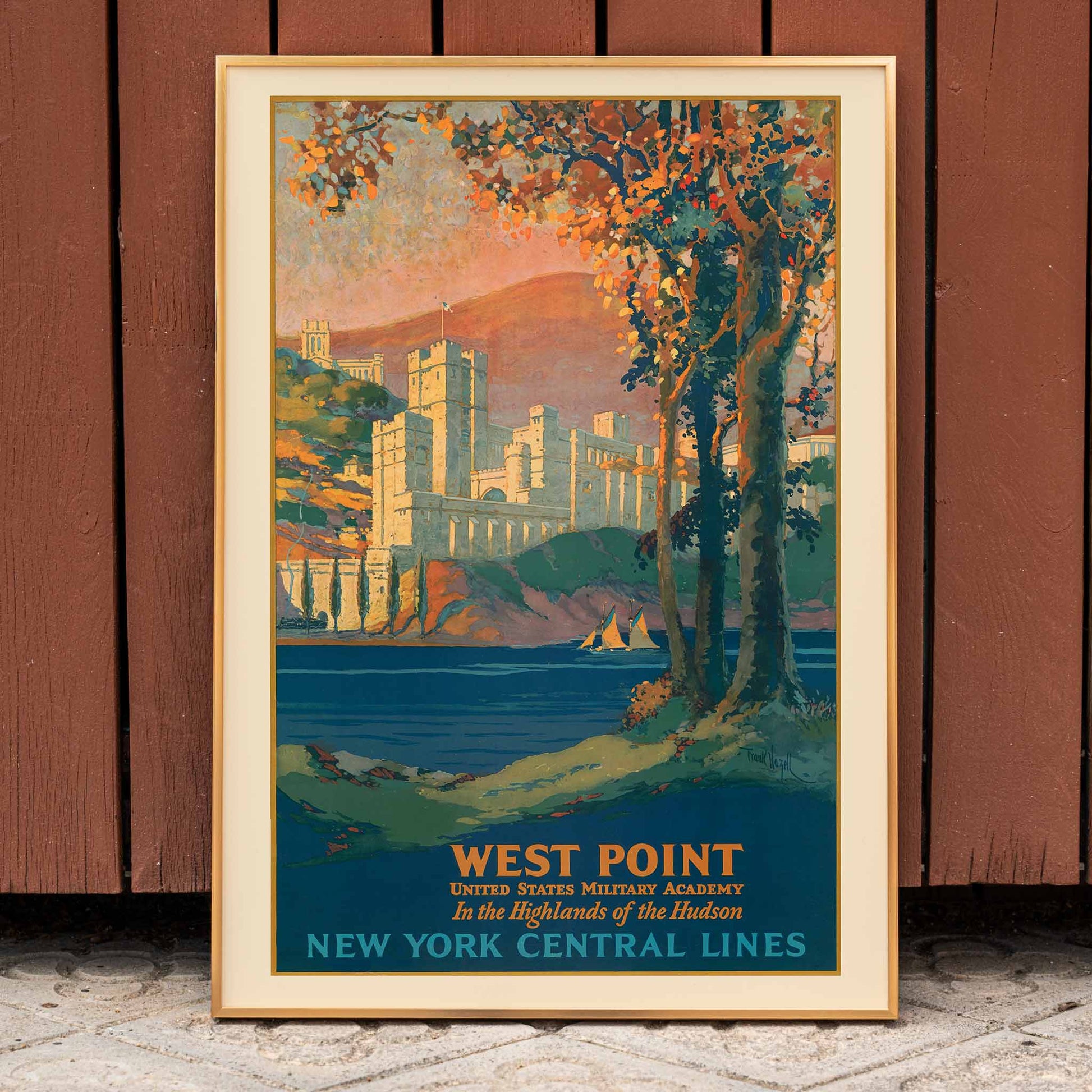 Colorful painting by Frank Hazell of West Point United States Military Academy by the Hudson River surrounded by trees and mountains, framed and displayed in home decor