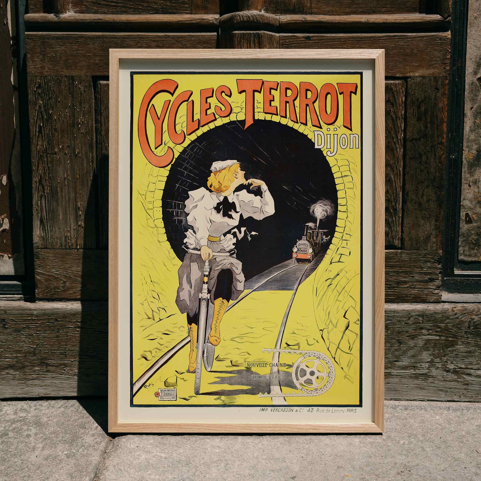 Vintage poster of a woman riding a bicycle in a tunnel with a train approaching Cycles Terrot Dijon artwork, framed and displayed in home decor
