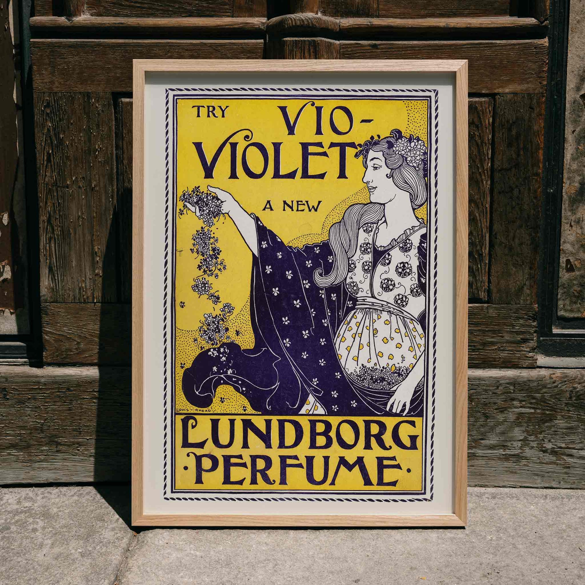 Art Nouveau perfume poster by Louis Rhead featuring a woman holding flowers with floral motifs, framed and displayed in home decor