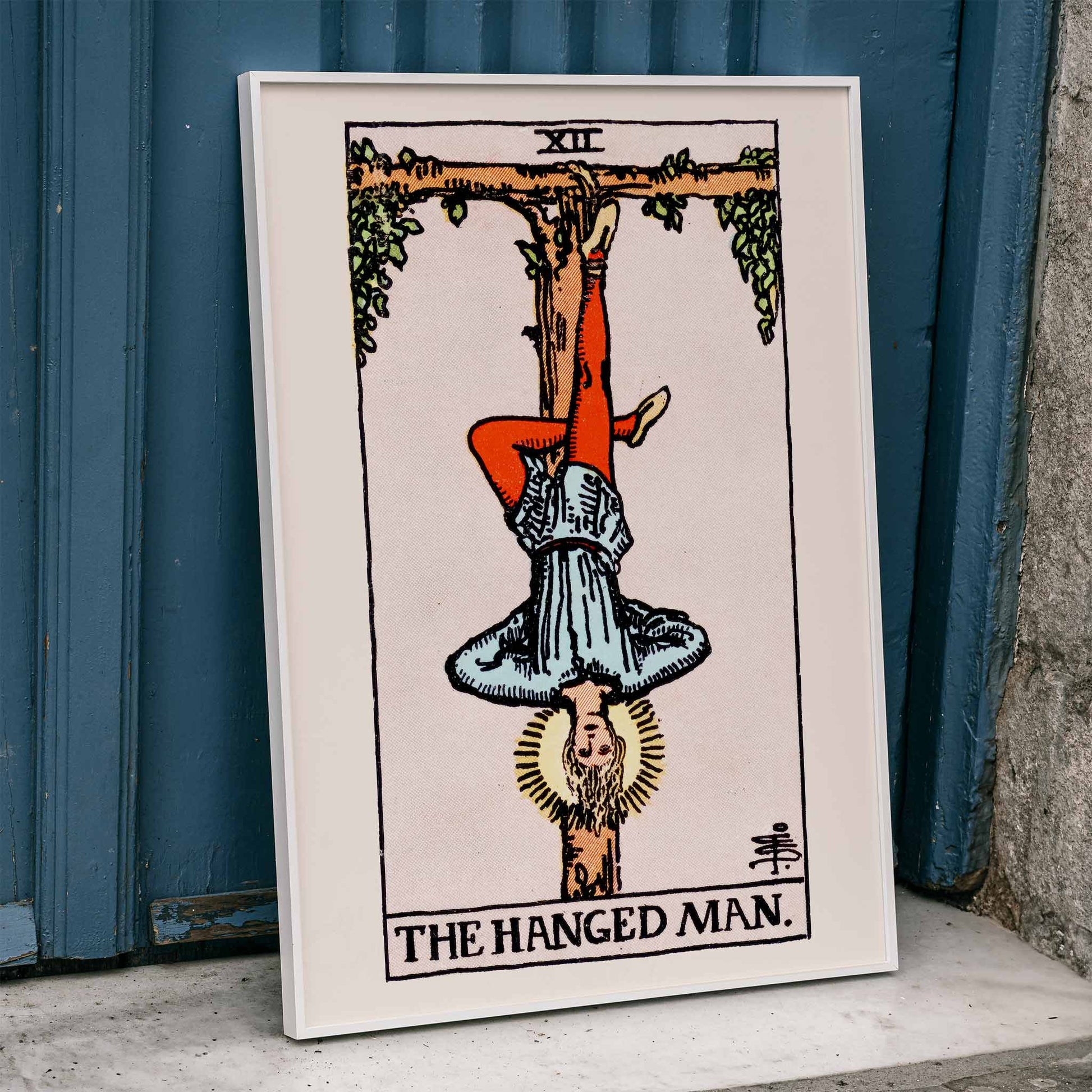 Hanged Man Tarot Card by Rider Waite, figure hanging upside down from wooden structure, mystical poster art, framed and displayed in home decor