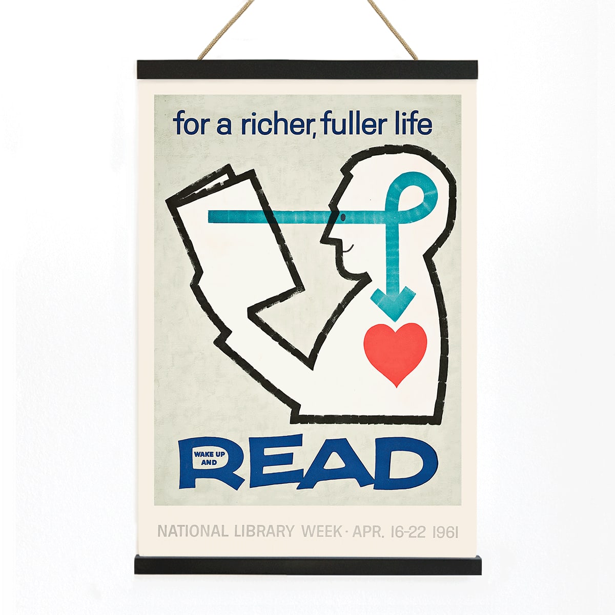 Poster with a stylized person reading a book and heart with bold text for a richer fuller life wake up and read by National Library, with wooden magnetic frame on white background